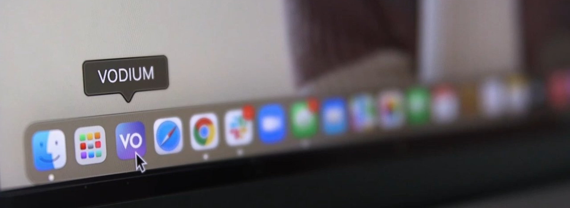 Blurred close-up of a desktop dock with the VODIUM app icon and tooltip